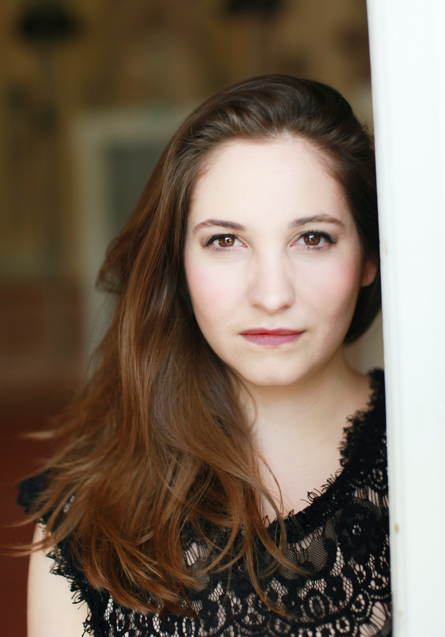 eine Frau mit einem schwarzen Oberteil vor einem verschwommenen Hintergrund