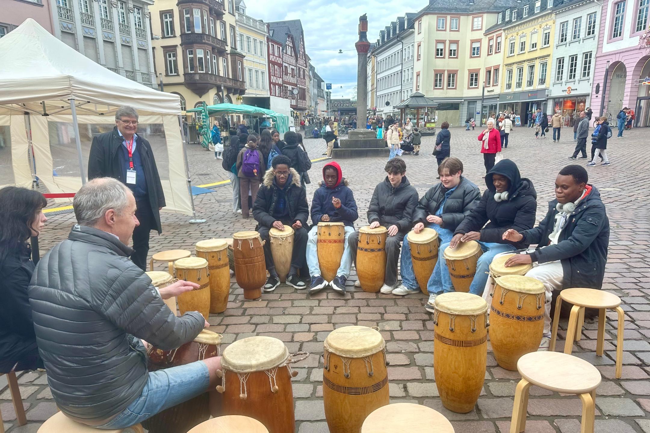 mehrere Menschen machen gemeinsam Musik auf dem Trierer Hauptmarkt