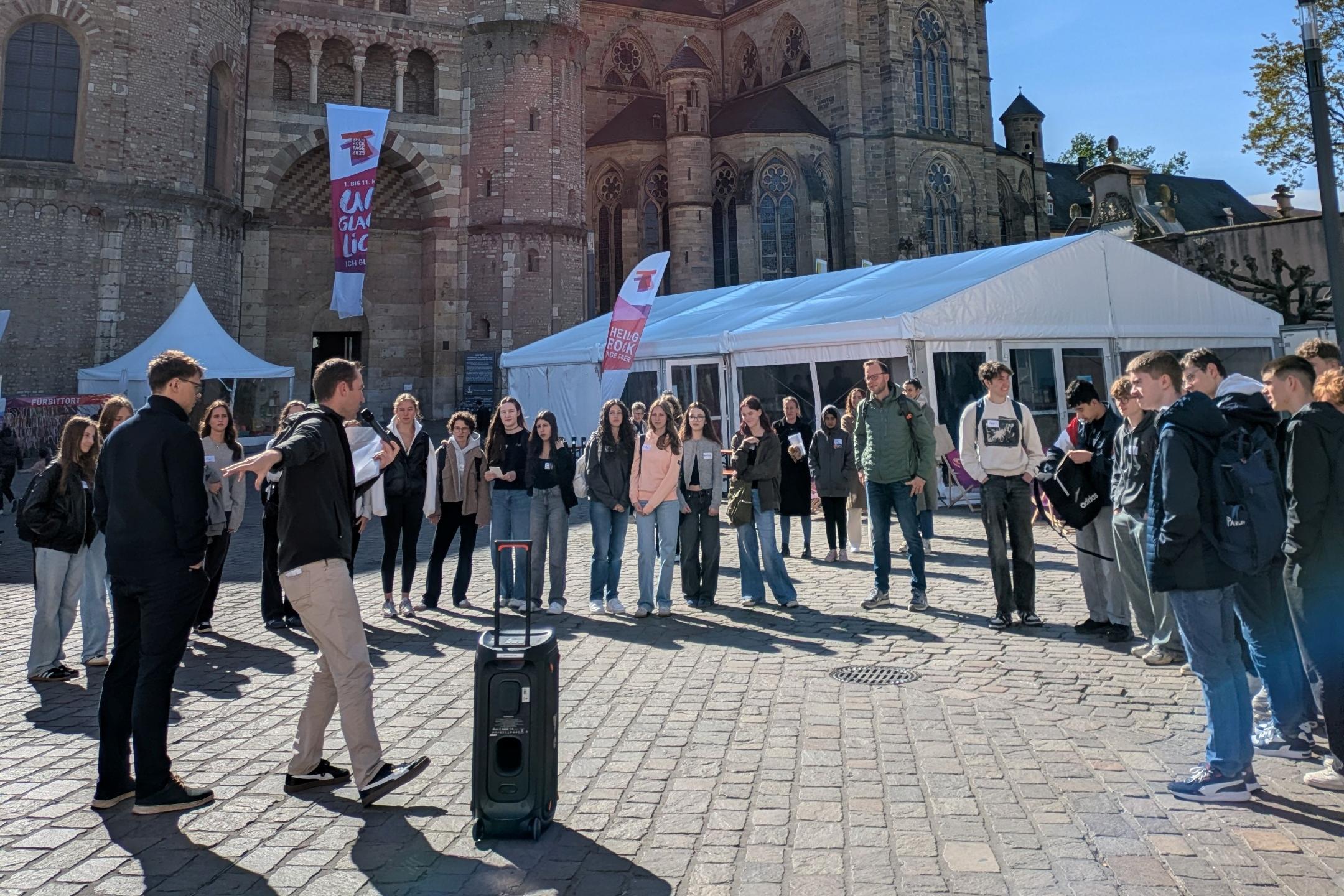 Eine Gruppe von Schülern Spielt vor dem Trierer Dom ein Kennlernspiel