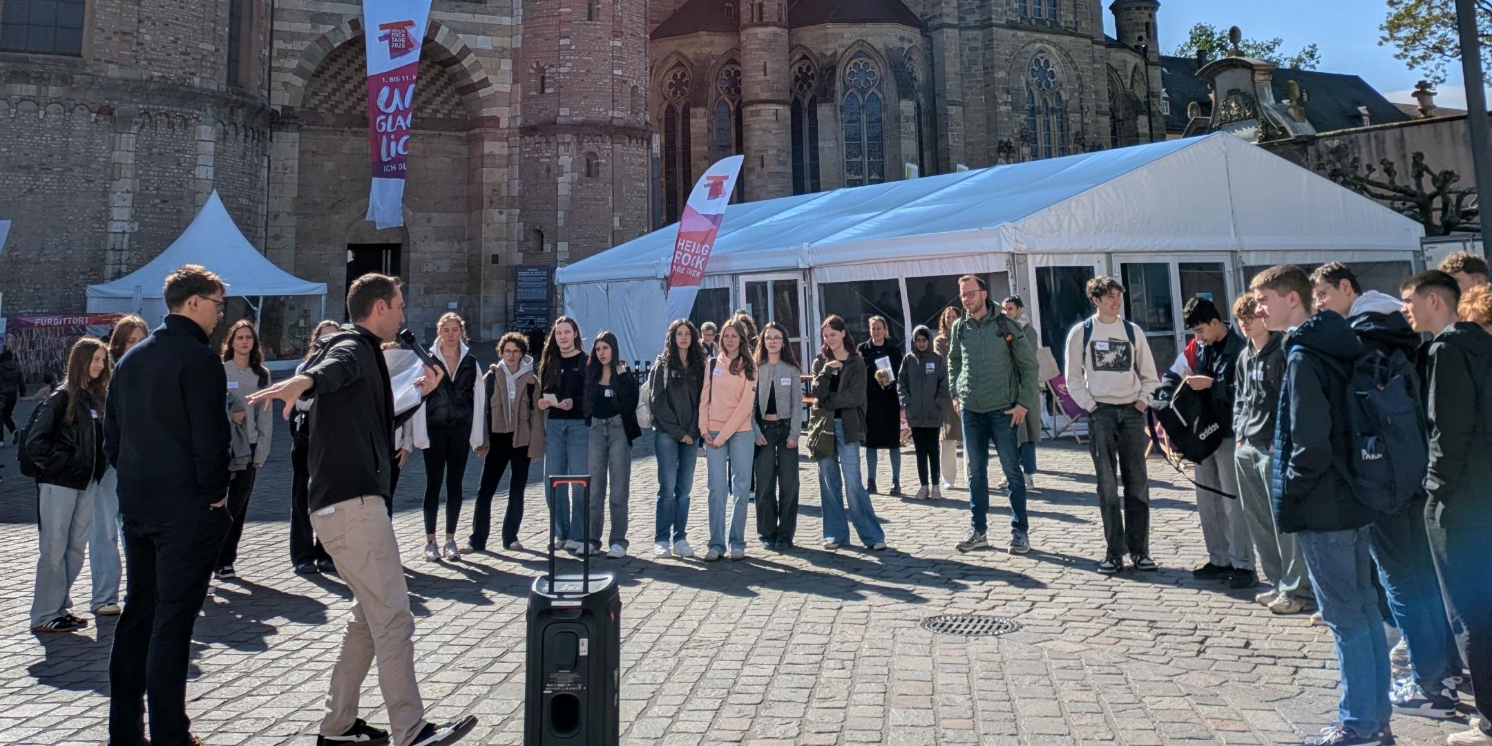 Eine Gruppe von Schülern Spielt vor dem Trierer Dom ein Kennlernspiel