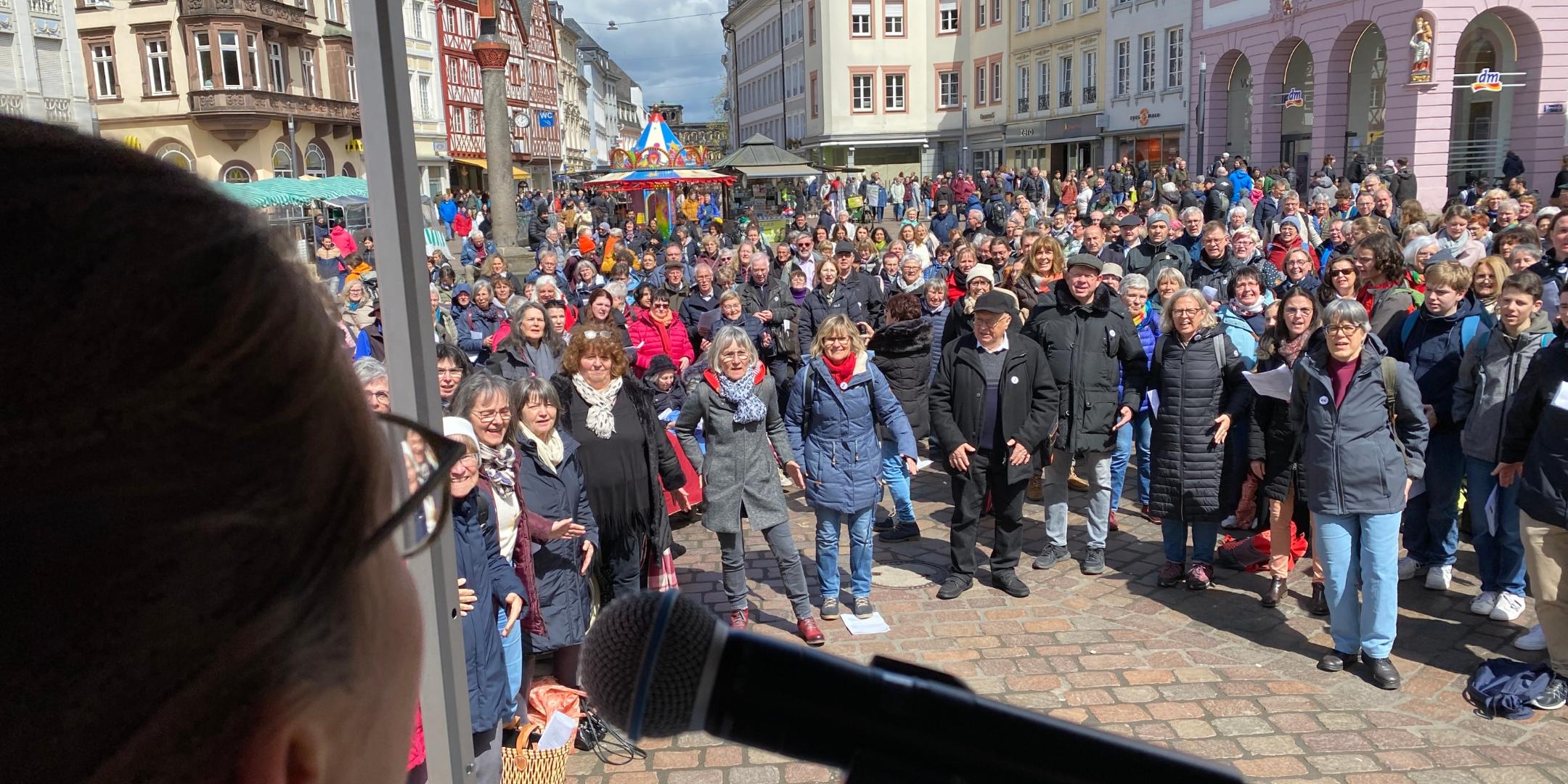 Blick von einer Bühne auf eine große Menschengruppe