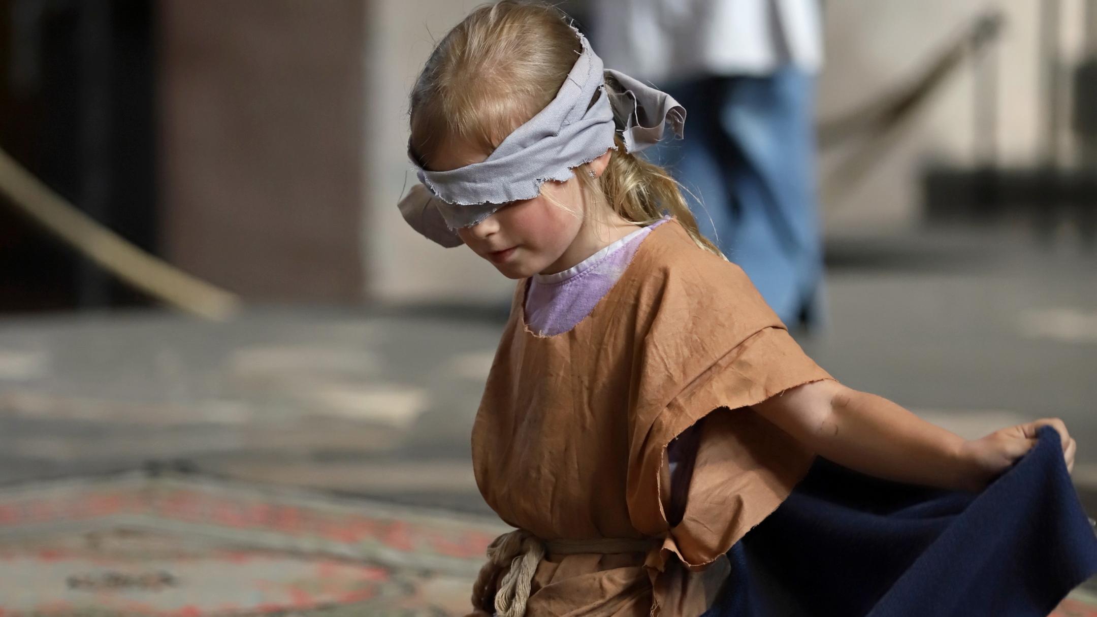 Die Kinder der Nikolaus Groß Schule aus Lebach stellen die Geschichte des blinden Bartimäus nach, der von Jesus geheilt wird