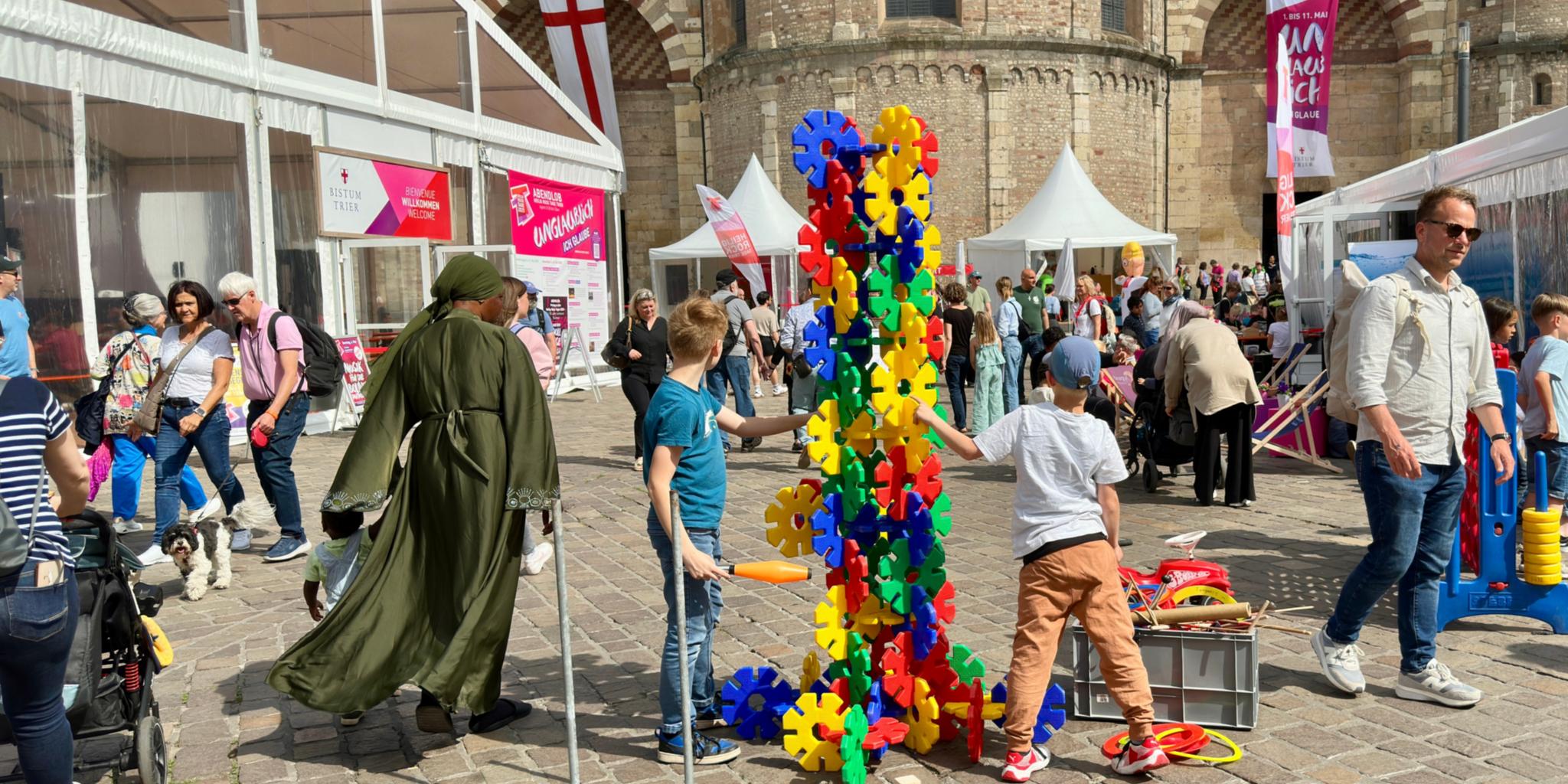 Menschen und Spielgeräte auf dem Platz vor dem Dom