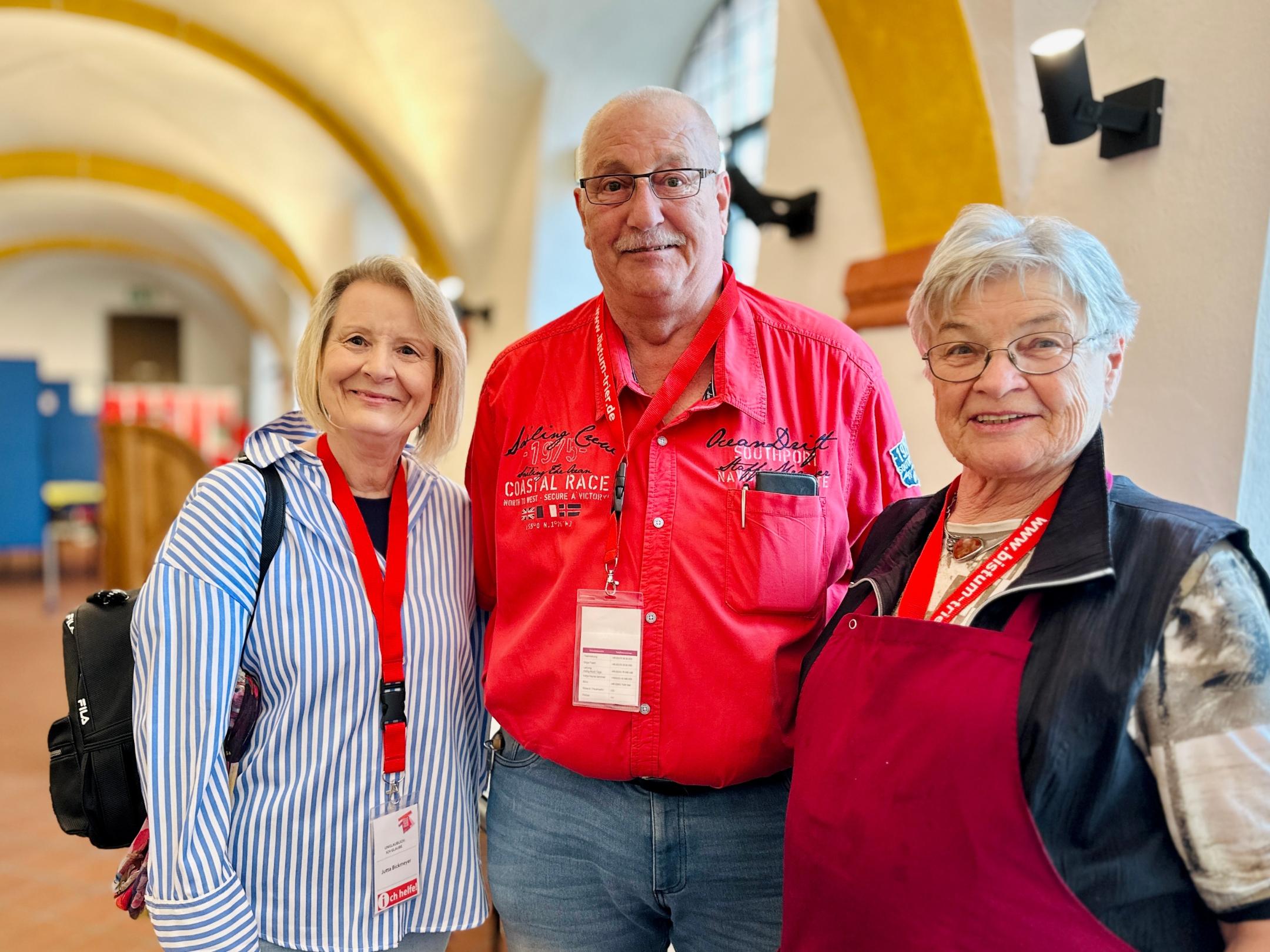 Drei ältere Menschen lächeln in die Kamera