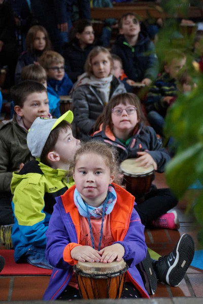 Kinder mit und ohne Behinderung im Trierer Dom mit Trommeln in den Händen