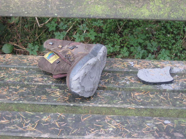 Ein Pilgerschuh mit einer kaputten Sohle
