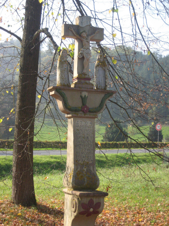 Am Wegrand steht ein Kreuz aus Stein