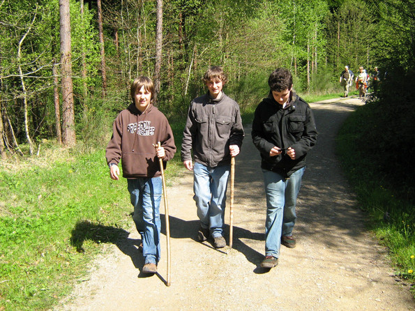 drei junge Männer mit Stöcken